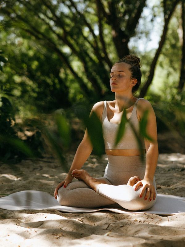 Calm woman meditating in a serene nature setting with closed eyes.