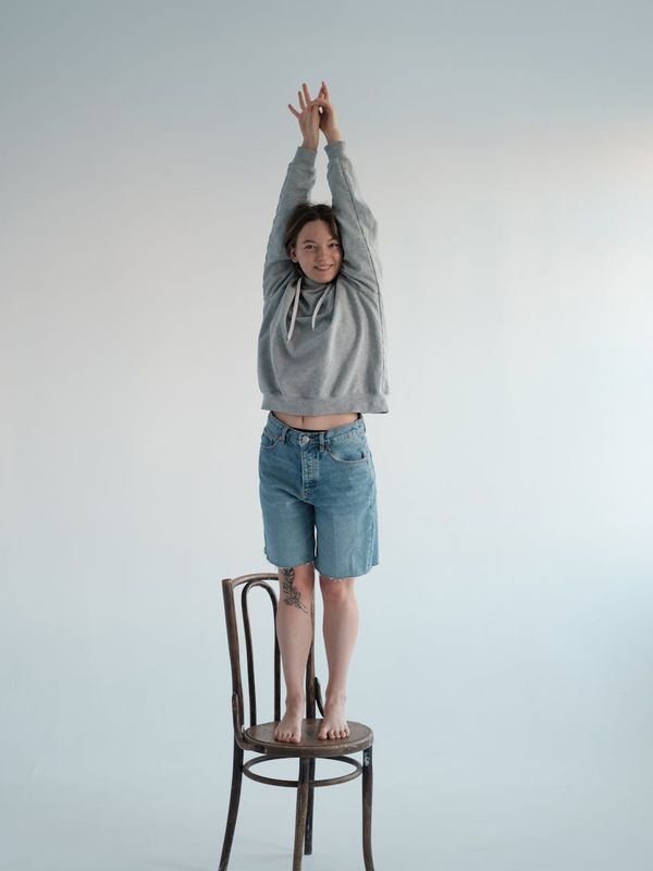 Woman smiling and stretching in a bright, modern studio.